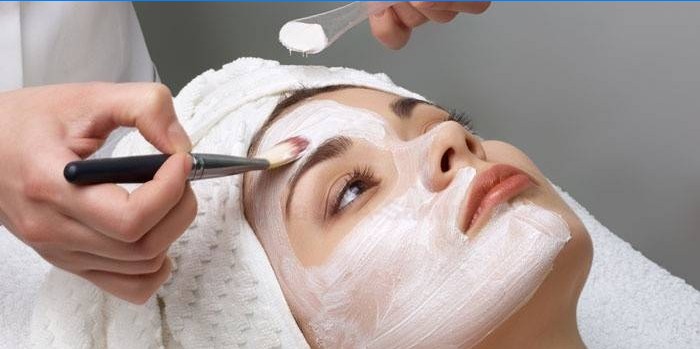 Esteticista aplica productos de limpieza en la cara del paciente.