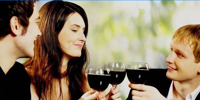 Hombres y mujeres beben vino