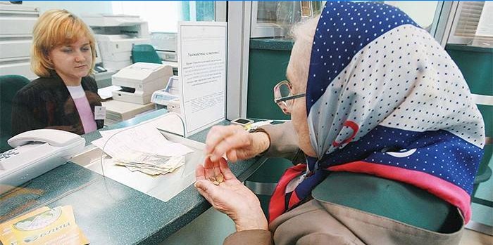 Anciana recibe una pensión en el banco