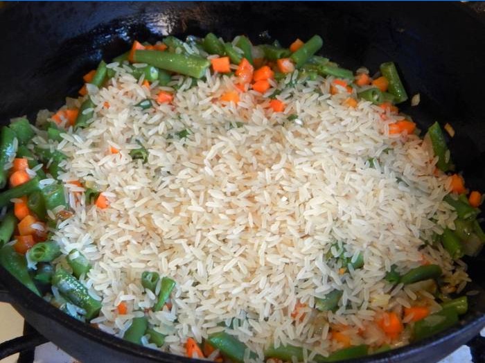 Agregue arroz a una sartén con verduras