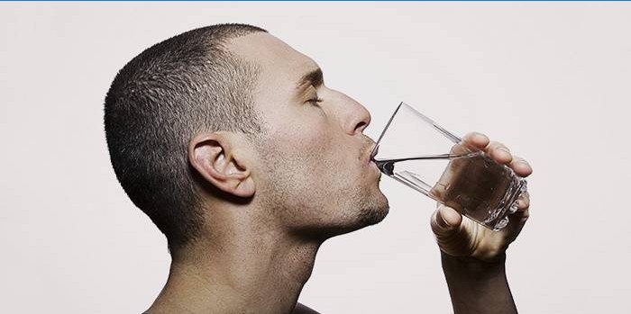 Un hombre bebe agua en una dieta rápida para bajar de peso