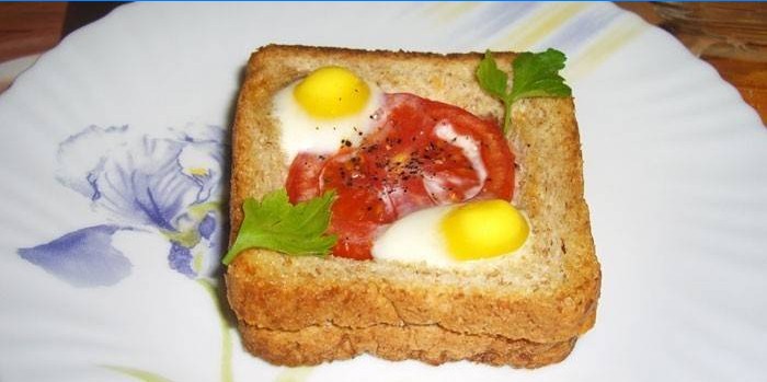 Sándwich caliente con huevos de codorniz y tomate en un plato