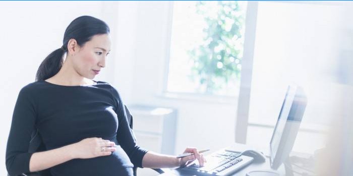 Mujer embarazada en la computadora