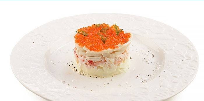 Sirviendo ensalada de calamar con caviar rojo