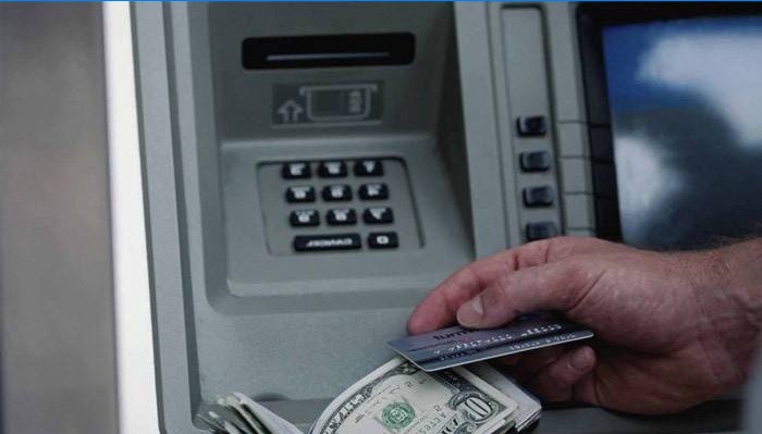Un hombre recibe dinero en un cajero automático.