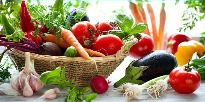 Verduras en la cesta y sobre la mesa