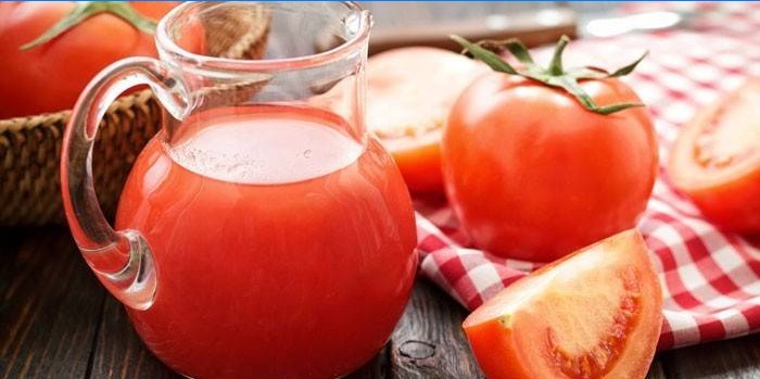 Jugo de tomate en una jarra y tomate