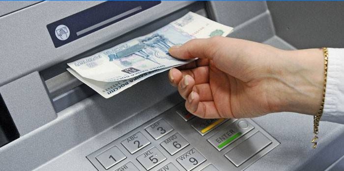 Niña recibe dinero en efectivo en un cajero automático