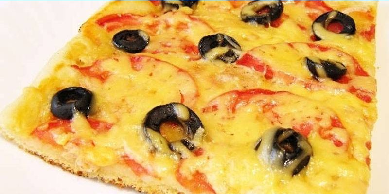 Pizza con piña, aceitunas y tomates.