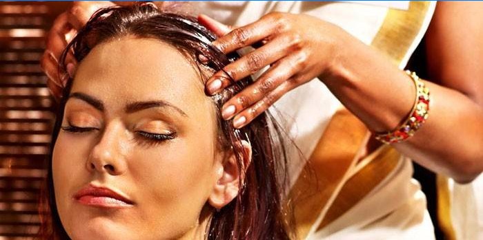 Mujer haciendo masaje de aceite en la cabeza