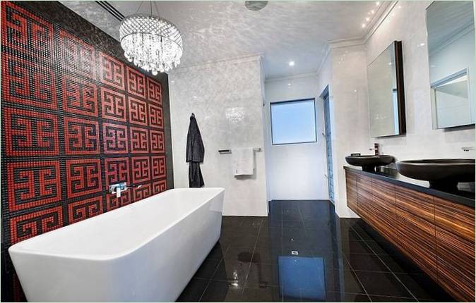 Elegante panel de mosaico rojo y negro en el baño