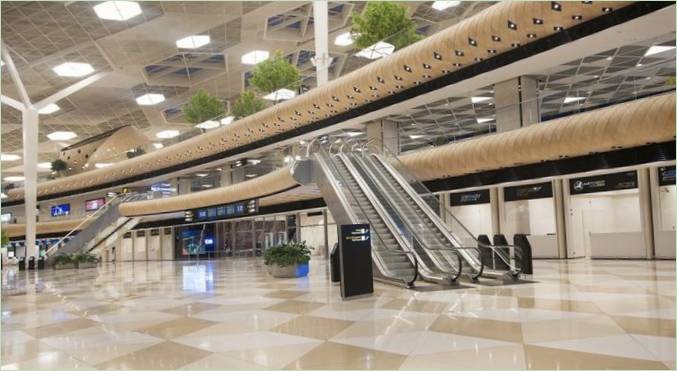Sala VIP del aeropuerto: un amplio hall de entrada con una escalera mecánica